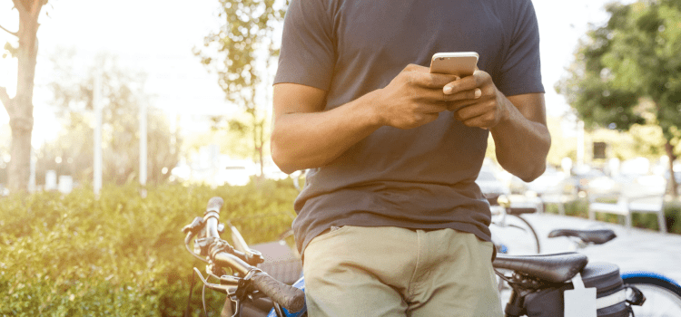 man using phone sitting on bike