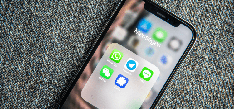 phone on desk with messenger apps on screen