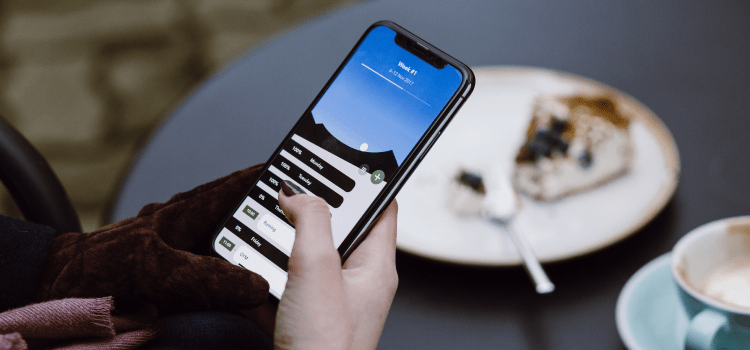 person at cafe scrolling on phone screen