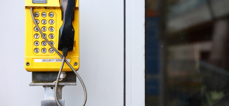 yellow payphone on wall